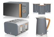 A set of Swan Nordic kitchen appliances in grey color, including a 1.7L cordless kettle, a 4 slice toaster, and a 800W 20L digital microwave, along with three canisters for storing tea, coffee, and sugar.